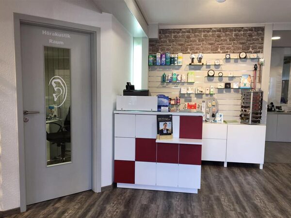 Moderner Empfangsbereich eines Hörakustikers mit Tresen und Hörgeräte-Zubehör.